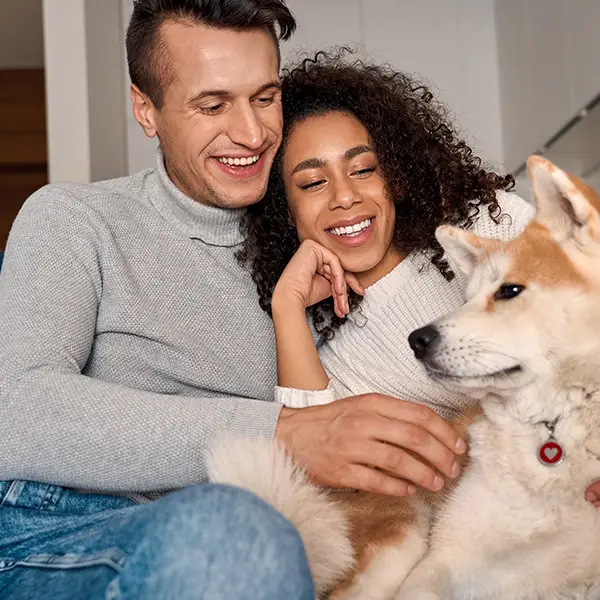 nice couple cuddling their dog on couch